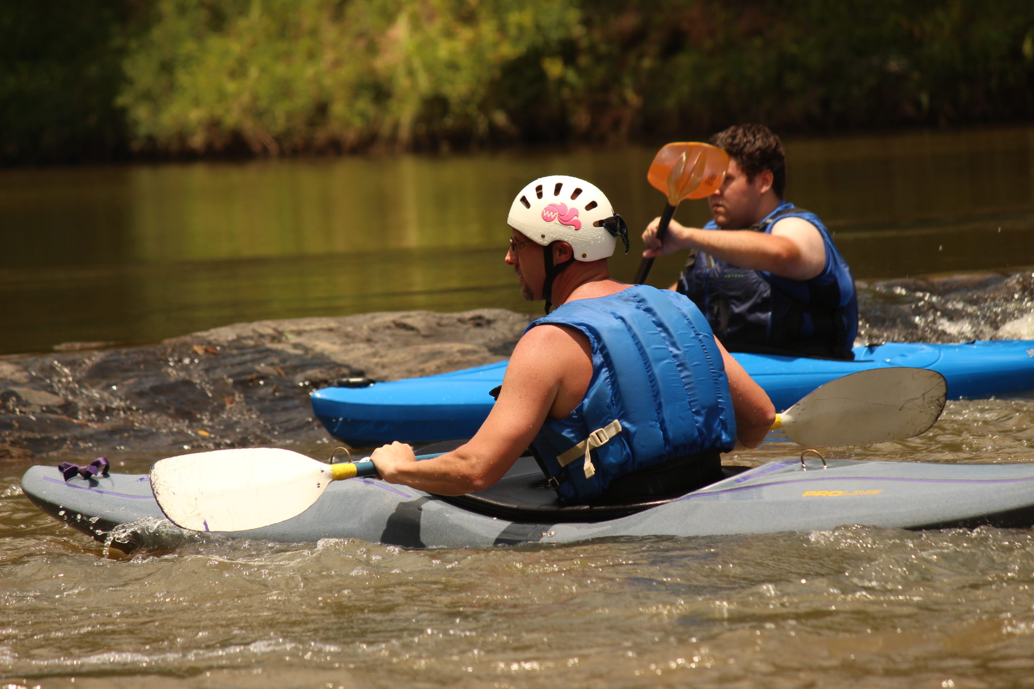 Friends kayaking down a river in Villa Rica, GA